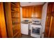 Neat laundry room has a washer, dryer, and built-in wooden shelves at 20 Lisa Ct, Stockbridge, GA 30281