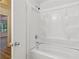 Clean bathtub with showerhead, with a glimpse into an adjacent bedroom at 310 Wolf Downs Way, Atlanta, GA 30349