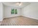 Bright bedroom features wood-look flooring, neutral paint, and natural light at 310 Wolf Downs Way, Atlanta, GA 30349