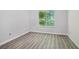 Bedroom features grey wood flooring, neutral paint, white trim, and a view to the outside at 310 Wolf Downs Way, Atlanta, GA 30349