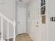 Bright entryway featuring tile flooring, a staircase, and a solid front door with glass panels at 310 Wolf Downs Way, Atlanta, GA 30349