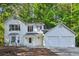 Charming two-story home featuring a two-car garage, bay window, and well-manicured front yard at 310 Wolf Downs Way, Atlanta, GA 30349