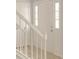 A bright, white paneled front door accented with decorative sidelights and staircase at 310 Wolf Downs Way, Atlanta, GA 30349