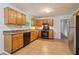 Kitchen featuring wood cabinets, tile flooring, black appliances, and a stainless steel fridge at 310 Wolf Downs Way, Atlanta, GA 30349