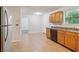 Traditional kitchen with stainless steel refrigerator, tile floors, and natural wood cabinets at 310 Wolf Downs Way, Atlanta, GA 30349