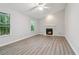 Living room with a fireplace, light walls, laminate floors, and two windows at 310 Wolf Downs Way, Atlanta, GA 30349