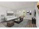 Inviting living room with modern decor, gray rug, and views into the dining area at 310 Wolf Downs Way, Atlanta, GA 30349