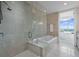 Bright bathroom features a soaking tub with shower and an open doorway leading to the main bedroom with a view at 3630 Peachtree Ne Rd # 2408, Atlanta, GA 30326