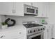Close up of kitchen with stainless steel appliances, white cabinetry and modern backsplash at 3630 Peachtree Ne Rd # 2408, Atlanta, GA 30326