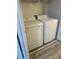 Laundry room features white appliances, overhead storage, and wood-look flooring at 3785 Somerset Sw Dr, Marietta, GA 30064