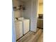 Laundry room features white appliances, overhead storage, and wood-look flooring at 3785 Somerset Sw Dr, Marietta, GA 30064
