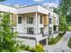 Modern three-story home with clean white exterior, accented by wood paneling and large windows at 536 Highland Ne Ave # A, Atlanta, GA 30312