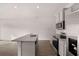 Bright kitchen features an island with granite counters, stainless steel appliances, and gray cabinets at 1410 Aura Ln, Lawrenceville, GA 30045