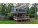 Backyard featuring a home with a deck with a pergola and lush green lawn surrounded by mature trees at 233 Oakridge Se Dr, Cartersville, GA 30121