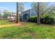 Backyard view of a blue two-story home, deck with a pergola, and lush green lawn surrounded by mature trees at 233 Oakridge Se Dr, Cartersville, GA 30121