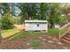 View of a white backyard shed with double doors and a gray roof in the backyard at 233 Oakridge Se Dr, Cartersville, GA 30121