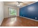 Spacious bedroom with hardwood floors, blue accent wall and a large window at 233 Oakridge Se Dr, Cartersville, GA 30121