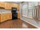 Bright kitchen featuring wooden cabinets, black appliances, and a window with natural light at 233 Oakridge Se Dr, Cartersville, GA 30121