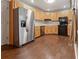 Well-lit kitchen with stainless steel refrigerator, black oven, and wood cabinets at 233 Oakridge Se Dr, Cartersville, GA 30121