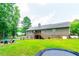 Large backyard with mature trees, a deck, trampoline, and space for entertaining and recreation at 2430 Tribble Creek Cv, Grayson, GA 30017