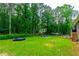 Expansive backyard has mature trees, a trampoline, fire pit, and space for outdoor activities at 2430 Tribble Creek Cv, Grayson, GA 30017