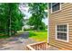 Side yard with driveway and partial view of the house with lush, green space at 2430 Tribble Creek Cv, Grayson, GA 30017