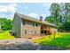 Exterior view showing the back of the home with a deck, spacious yard, and mature trees at 2430 Tribble Creek Cv, Grayson, GA 30017