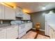 The basement kitchen has white cabinets, granite countertops, and modern appliances for convenience and style at 2430 Tribble Creek Cv, Grayson, GA 30017