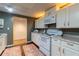 Finished basement kitchenette with white cabinets and appliances, leading to hallway at 2430 Tribble Creek Cv, Grayson, GA 30017