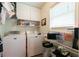 Bright laundry room with storage shelves, white cabinets and modern appliances at 2430 Tribble Creek Cv, Grayson, GA 30017