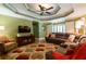 Spacious living room with a large sofa, entertainment center, and modern ceiling fan at 2430 Tribble Creek Cv, Grayson, GA 30017