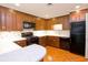 Traditional kitchen with wood cabinets, black appliances, and breakfast bar area at 2734 Peachtree Nw Rd # C-404, Atlanta, GA 30305
