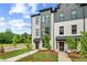 Modern townhome exterior featuring white brick, sleek black accents, and beautifully landscaped grounds at 449 Breccia Run, Mcdonough, GA 30253