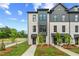 Stylish townhome exterior with white brick, black trim, and professionally landscaped front yard at 449 Breccia Run, Mcdonough, GA 30253
