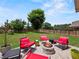 Inviting backyard with a stone patio, red rocking chairs, and a fire pit, perfect for outdoor gatherings and relaxation at 5730 Arbor Green Cir, Sugar Hill, GA 30518