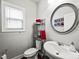 Cozy powder room with decorative mirror, modern fixtures, and open shelving for storage at 5730 Arbor Green Cir, Sugar Hill, GA 30518