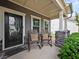 Inviting front porch with rocking chairs and stone accents for a cozy, welcoming entrance to the home at 5730 Arbor Green Cir, Sugar Hill, GA 30518