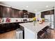 Modern kitchen showcasing dark wood cabinets, granite countertops, stainless steel appliances, and a kitchen island with seating at 5730 Arbor Green Cir, Sugar Hill, GA 30518