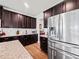 Charming kitchen featuring dark cabinets and stainless steel appliances, blending style and functionality at 5730 Arbor Green Cir, Sugar Hill, GA 30518