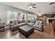 Open-concept living room with a fireplace, ceiling fan, and comfortable seating with views to the dining and kitchen area at 5730 Arbor Green Cir, Sugar Hill, GA 30518