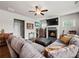 Comfortable living room with a fireplace, TV, ceiling fan, and a large sectional sofa, perfect for relaxation at 5730 Arbor Green Cir, Sugar Hill, GA 30518