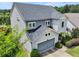 An elevated side view of a two-story home with a two-car garage and welcoming front porch at 5730 Arbor Green Cir, Sugar Hill, GA 30518