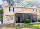 Two-story home with a screened-in porch, stone detail and black shutters at 1225 Creek Forest Nw Ct, Conyers, GA 30012