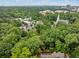 Aerial view of a neighborhood with mature trees and a church in the distance at 1478 Oxford Ne Rd, Atlanta, GA 30307