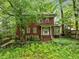 Charming two-story brick home with a covered front porch and partially overgrown landscaping at 1478 Oxford Ne Rd, Atlanta, GA 30307