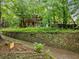 Traditional two-story brick home with a stone retaining wall and mature trees at 1478 Oxford Ne Rd, Atlanta, GA 30307