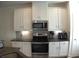 Modern kitchen with stainless steel appliances, white cabinetry, and granite countertops at 1942 Dillon Dr, Lithonia, GA 30058