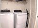 Bright laundry room features a white washer, dryer, and wire shelving at 1942 Dillon Dr, Lithonia, GA 30058