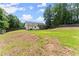 Spacious backyard with a large lawn, bordered by mature trees and a wooden fence at 2605 Fort Apachee Trl, Dacula, GA 30019