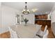 Dining room with modern chandelier, white wood trim, and a view of the stainless steel appliances at 2605 Fort Apachee Trl, Dacula, GA 30019